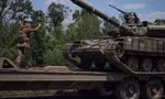 Một lính Ukraine hướng dẫn xe tăng lên xe tải ở vùng Donest ngày 8/6. (Ảnh: Reuters)