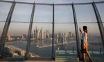 Một phụ nữ đang chụp ảnh bằng điện thoại từ toà tháp ở Dubai. (Ảnh: Reuters)