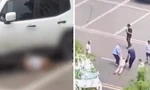 Chiếc xe trắng nhiều lần cán lên người nạn nhân ở bãi đỗ. (Ảnh từ clip)