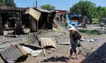 Một cụ bà đi qua khu chợ đổ nát ở Donetsk ngày 19/6. (Ảnh: Reuters)
