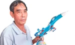 Ông Bùi Xuân Thành với chiếc máy bay chiến đấu mô hình đã hoàn thành Ảnh: Nguyễn Thành