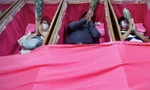 Nằm trong quan tài mở là cách mà nhiều người tin rằng có thể giúp xua vận đen. (Ảnh: ANN)