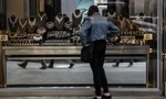 Một người đi đường ngắm trang sức kim cương trong cửa hàng ở New York. (Ảnh: Getty)