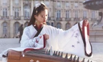 Cô gái mặc cổ phục gảy đàn trên đường phố