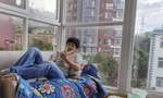 Guo Jianlong thảnh thơi nằm đọc sách trong căn hộ của anh ở tỉnh Vân Nam. (Ảnh: AP)