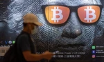 Một người đi qua bảng quảng cáo cho bitcoin ở Hong Kong ngày 25/9. (Ảnh: EPA)
