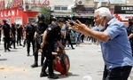 Một người đàn ông phản ứng khi cảnh sát bắt một người biểu tình ở Tunis ngày 25/7. (Ảnh: Reuters)