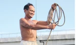 Ông Ba Chúc với cuộn dây dài dùng để cứu người.