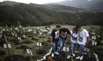 Thân nhân viếng mộ một nạn nhân COVID-19 ở Bogota (Colombia). Ảnh: AP