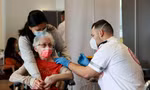 Một cụ bà Israel được tiêm vắc xin ở Netanya. Ảnh: Reuters