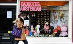 Một người phụ nữ đeo khẩu trang đi bộ ở Amsterdam (Hà Lan). Ảnh: Reuters