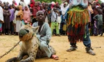 Bé trai ngồi lên lưng một con linh cẩu tại một gánh xiếc ở Nigeria. Ảnh: Reuters