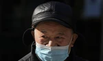 Một cụ ông đeo khẩu trang khi đi trên phố ở Bắc Kinh (Trung Quốc) ngày 14/12. Ảnh: AP