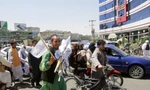 Một người đàn ông bán cờ Taliban ở thành phố Herat. Ảnh: AP