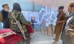 Một người bán cờ, poster Taliban ngay bên ngoài Đại sứ quán Mỹ ở Kabul. Ảnh: Reuters
