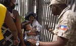 Cảnh sát Haiti yêu cầu người dân tránh xa khu vực Đại sứ quán Mỹ ở thủ đô Port-au-Prince trong bối cảnh nhiều người tụ tập bên ngoài, vẫy hộ chiếu để xin tị nạn ở Mỹ. Ảnh: AP