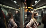 Một phụ nữ đeo khẩu trang khi đi tàu điện ngầm ở London. Ảnh: Reuters