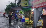 Mưa trắng trời, người dân TPHCM xách dép lội bì bõm trên quốc lộ