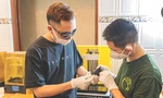 Hoàng Anh Tuấn (bên trái) đang vận hành máy in 3D 