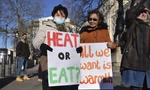 Những người Anh cầm biểu ngữ (Sưởi ấm hay ăn/Tất cả chúng tôi cần sự ấm áp) trong một cuộc biểu tình kêu gọi chính phủ giúp đỡ người dân chi trả hóa đơn năng lượng của họ. Ảnh: AP.