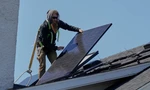 Một nhân viên đang lắp đặt tấm pin trên mái nhà ở Lakewood, Ohio, ngày 16/4. (Ảnh: AP)
