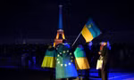 Người Ukraine cầm cờ Ukraine và châu Âu khi Tháp Eiffel được thắp sáng bằng màu cờ của Ukraine vào dịp tròn 3 năm nổ ra cuộc xung đột. (Ảnh: AP)