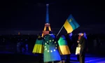 Người Ukraine cầm cờ Ukraine và châu Âu khi Tháp Eiffel được thắp sáng bằng màu cờ của Ukraine vào dịp tròn 3 năm nổ ra cuộc xung đột. (Ảnh: AP)