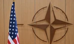 Logo của NATO bên cạnh quốc kỳ Mỹ. (Ảnh: Reuters)