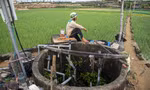 Lão nông Võ Hiển Vinh đang chờ bơm chạy vài phút rồi lại đi giếng khác bật cầu dao Ảnh: Văn Chương 