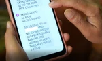 Người lao động kiểm tra tin nhắn báo nhận tiền hỗ trợ từ Quỹ Bảo hiểm thất nghiệp.