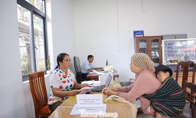 Cán bộ xã dùng song ngữ giúp dân làm thủ tục hành chính
