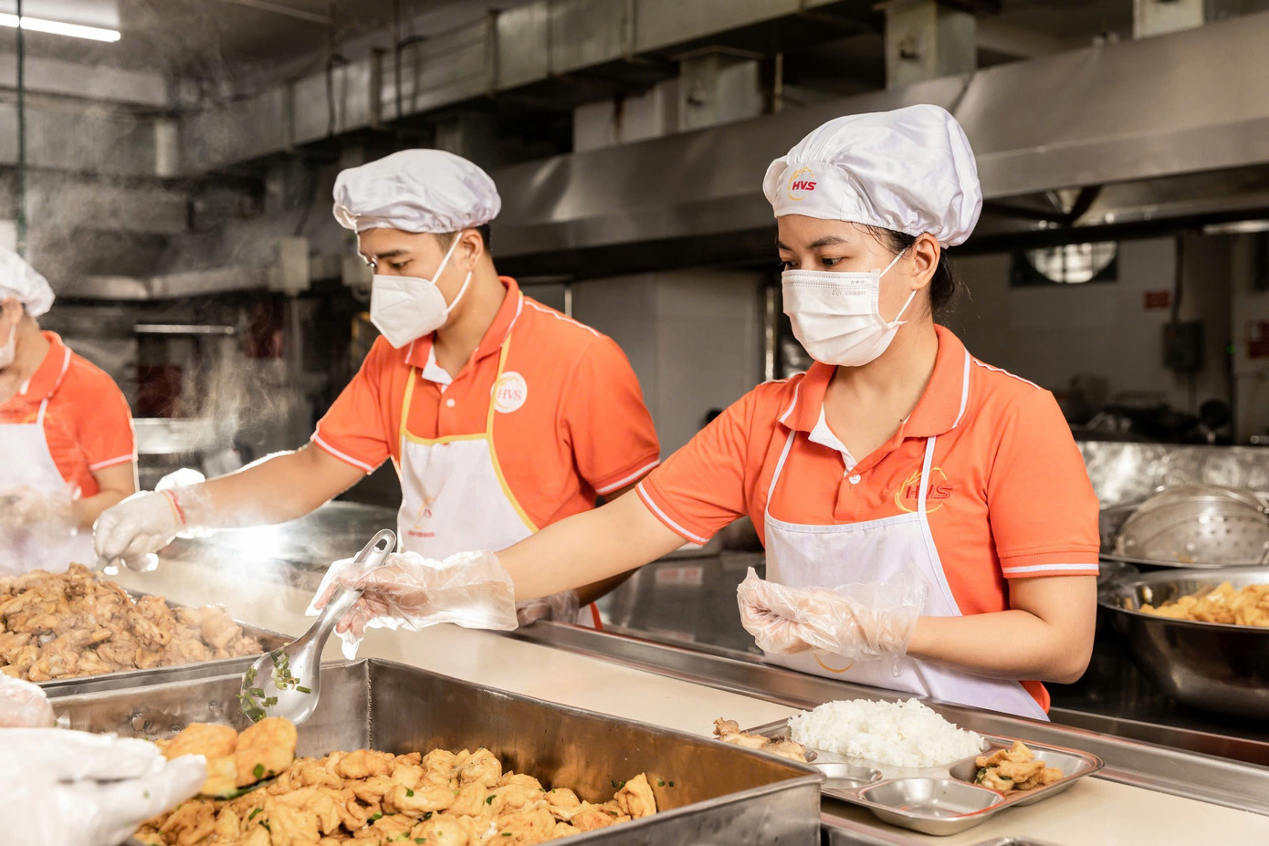 Funcionários da Companhia Huong Viet Sinh estão distribuindo refeições aos alunos. z7076573646960-c25f907c1f8e133a26f7646377b831ac.jpg