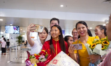Người hâm mộ đón, giao lưu với cầu thủ Huỳnh Như, đội trưởng đội tuyển bóng đá nữ Việt Nam tại Sân bay Nội Bài.
