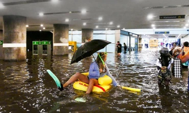 Mưa ngập ga tàu, dân ôm phao vịt bơi lội tung tăng