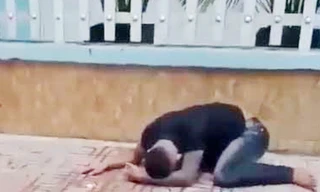 Thanh niên bị xịt hơi cay rồi nằm ôm mặt. Ảnh: Cắt từ clip