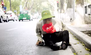 Tuấn lê lết trên đường Phan Đình Phùng. Ảnh: T.G