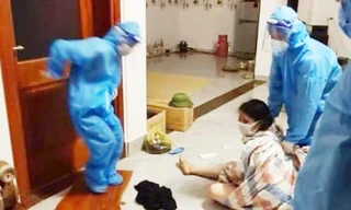 Lực lượng chức năng phải quấn bạt đưa người phụ nữ đi cách ly
