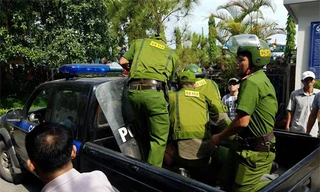 Cảnh sát đưa nam thanh niên lên xe đi về trụ sở