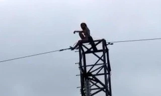Cảnh sát giải cứu cô gái khỏa thân ngồi trên cột điện cao thế