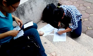 Thí sinh in sao tài liệu rồi cắt, dán, đóng gim bên ngoài cửa hàng photo. Ảnh: Minh Minh