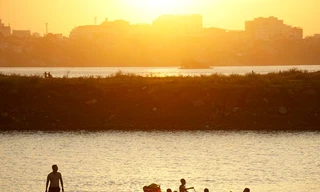 Dưới chân cầu Vĩnh Tuy phía tả ngạn sông Hồng, nhiều bãi bồi tự nhiên thoai thoải phủ cỏ xanh mướt đang trở thành những bãi tắm hấp dẫn người dân đổ về trong những ngày hè nóng nực. 