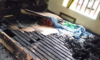 Chiếc giường nơi vợ chồng ông L đang ngủ bị đổ xăng đốt 
