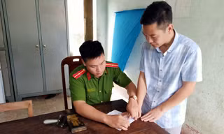 Bị can Hoàng Anh Tuấn (bìa phải) tại cơ quan điều tra - Ảnh: Công an cung cấp