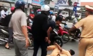 Cảnh sát giao thông bị 3 anh em An xô ngã. Ảnh: Cắt từ video
