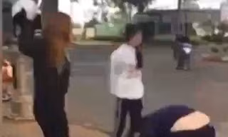 Hai nhóm nữ sinh dùng nón bảo hiểm để giải quyết mâu thuẫn. Ảnh: Cắt từ clip