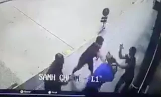 Anh H. (áo xanh) bị các đối tượng vây đánh. Ảnh cắt từ clip