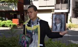 Anh Lê Anh Hào, bố của nạn nhân Nhật Linh, mang theo hai bức ảnh của con gái, một vui tươi, một khốn khổ, xuất hiện tại tòa. Ảnh: Cẩm Tuyến- Hồng Hà