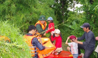 Chiến sĩ Đoàn Kinh tế - Quốc phòng 737 dùng ca nô đưa trẻ em ra khỏi vùng ngập lụt.