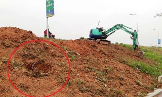 Hình ảnh máy xúc múc các hố để chôn lấp rác, gạch đá vào thân đê