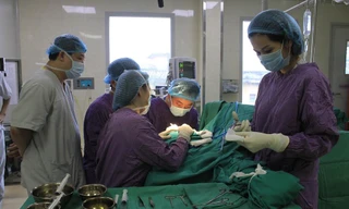 Các BS đang phẫu thuật tạo hình lại vành tai cho bệnh nhân. Ảnh: BV E cung cấp